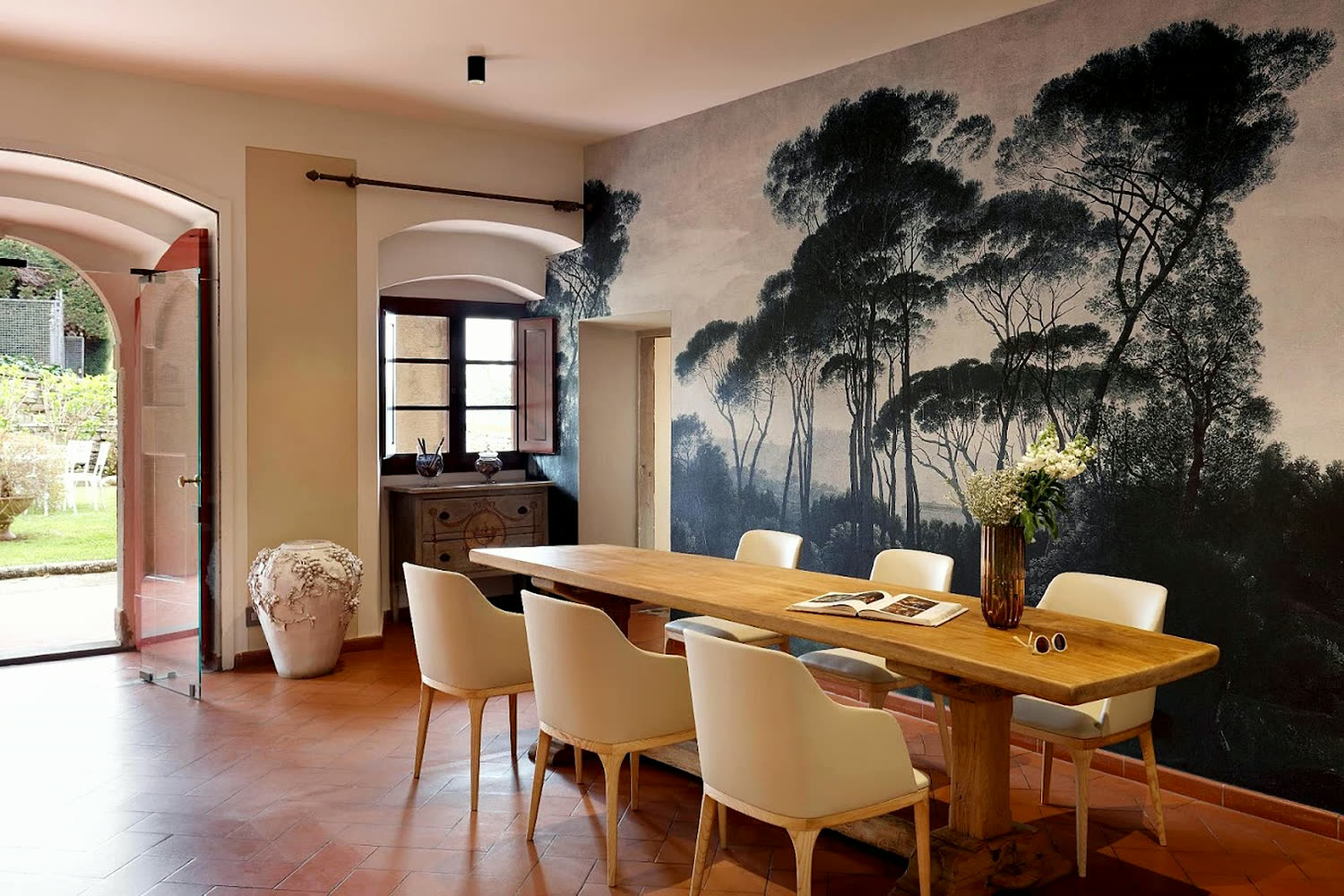 Sala da pranzo della tenuta, con la parete dipinta a pini marittimi.