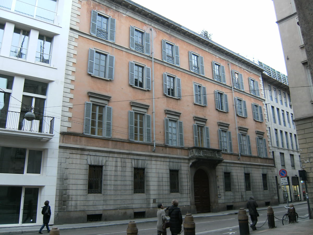 La facciata del palazzo lungo la via, vista da sotto il portico.